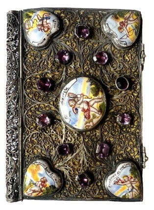 A miniature silver binding decorated with painted enamel plaques and glass “jewels.”